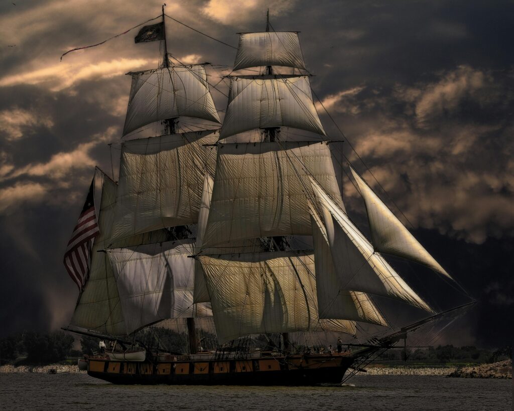 A majestic sailing ship with white sails against a dark, stormy sky, evoking a sense of adventure.